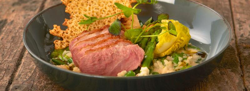 Risotto met eend groene groenten een saus van crème de cassis en een krokantje van Parmezaanse kaas